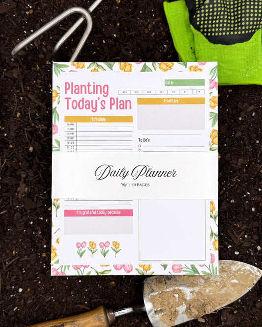 Daily planner sheet with gardening theme on a soil background with gardening tools.