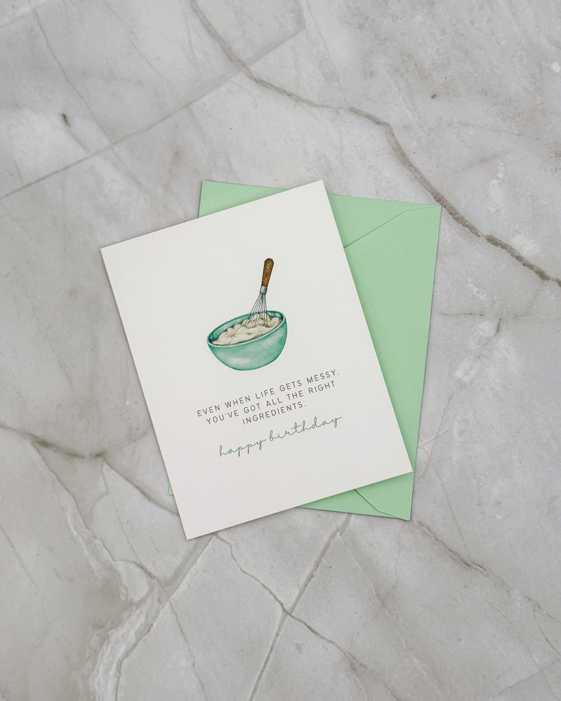 Greeting card with illustration of a mixing bowl and text on a light gray surface