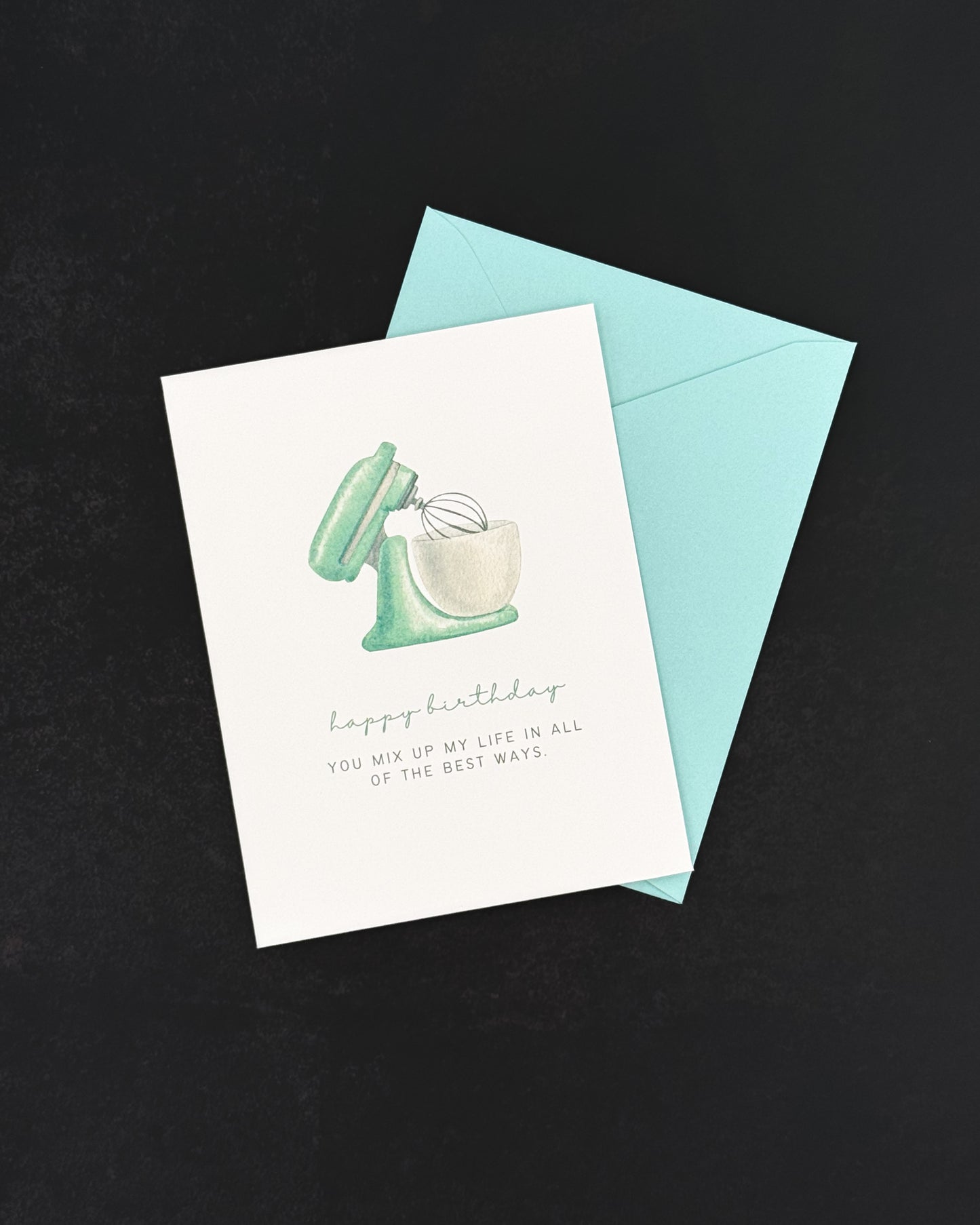 Greeting card with mixer illustration and blue envelope on black background