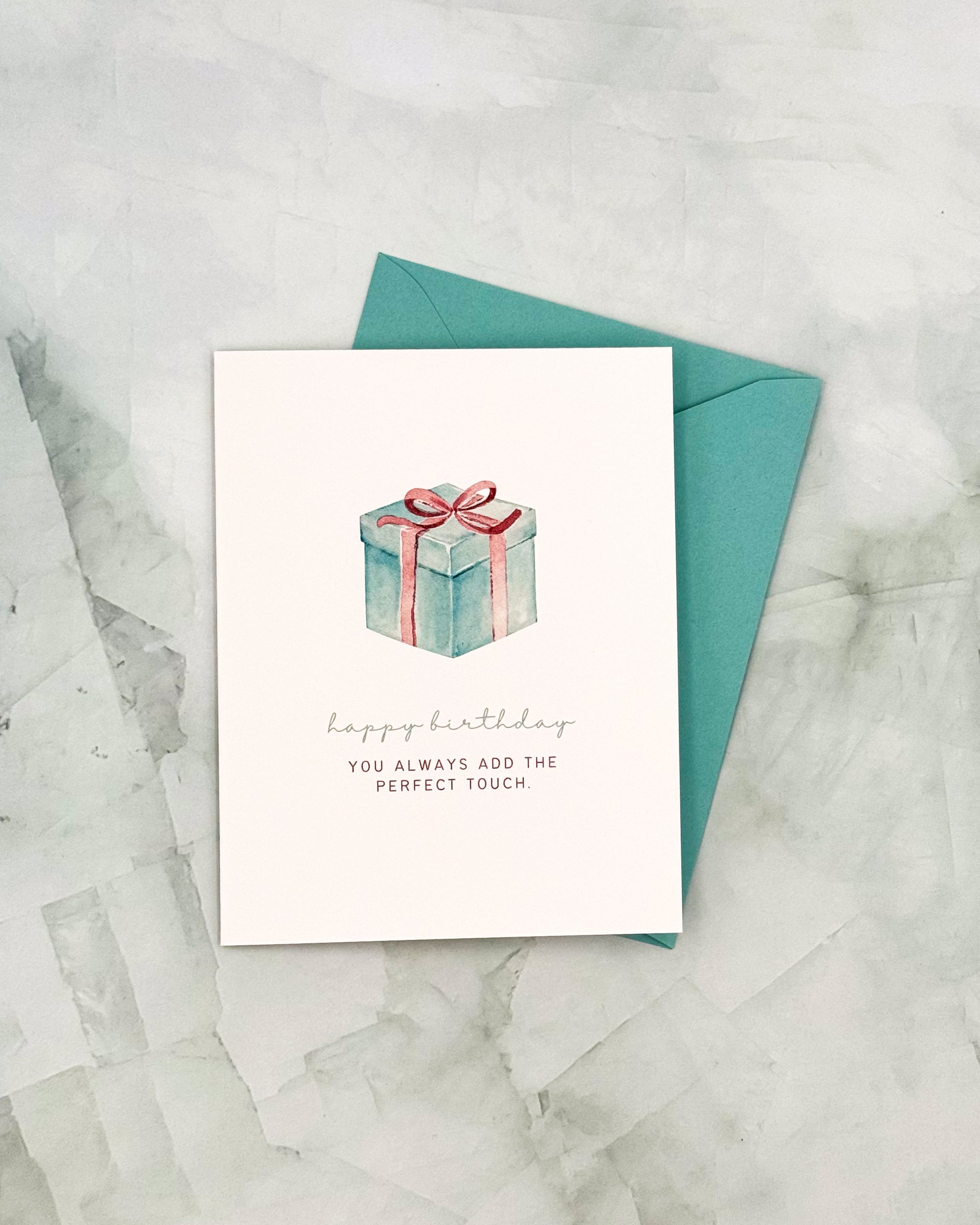 Greeting card with a gift illustration and text on a marble surface