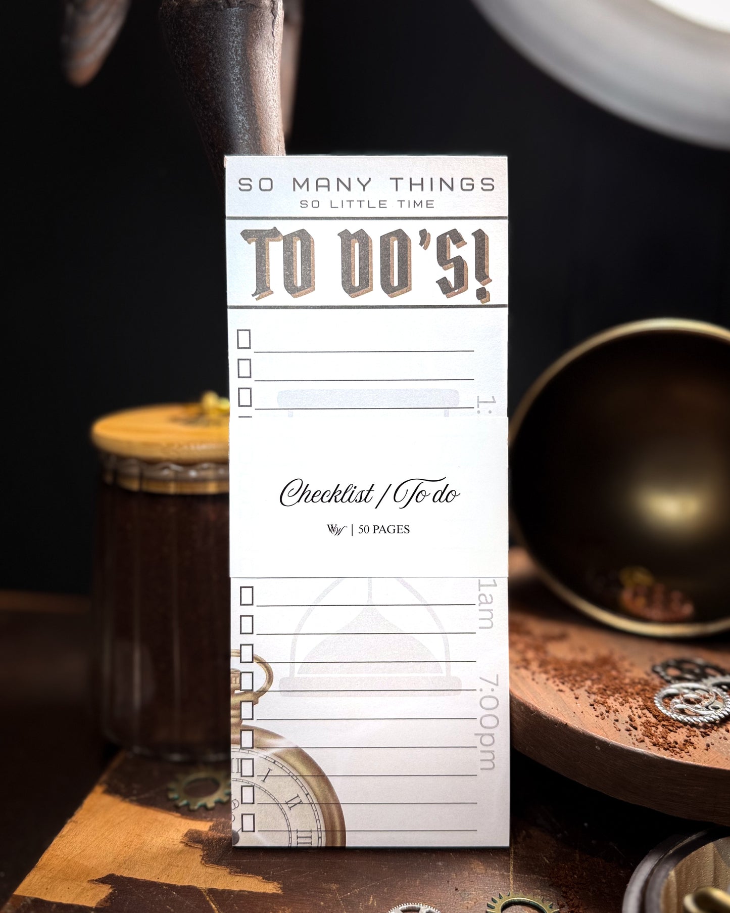 To-do list pad with a vintage design on a dark surface with a cup and saucer.