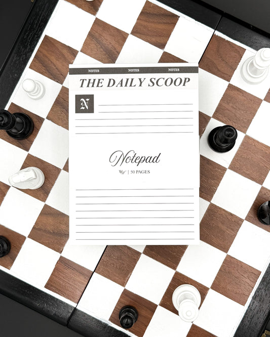 Notepad titled 'The Daily Scoop' on a chessboard with pieces.