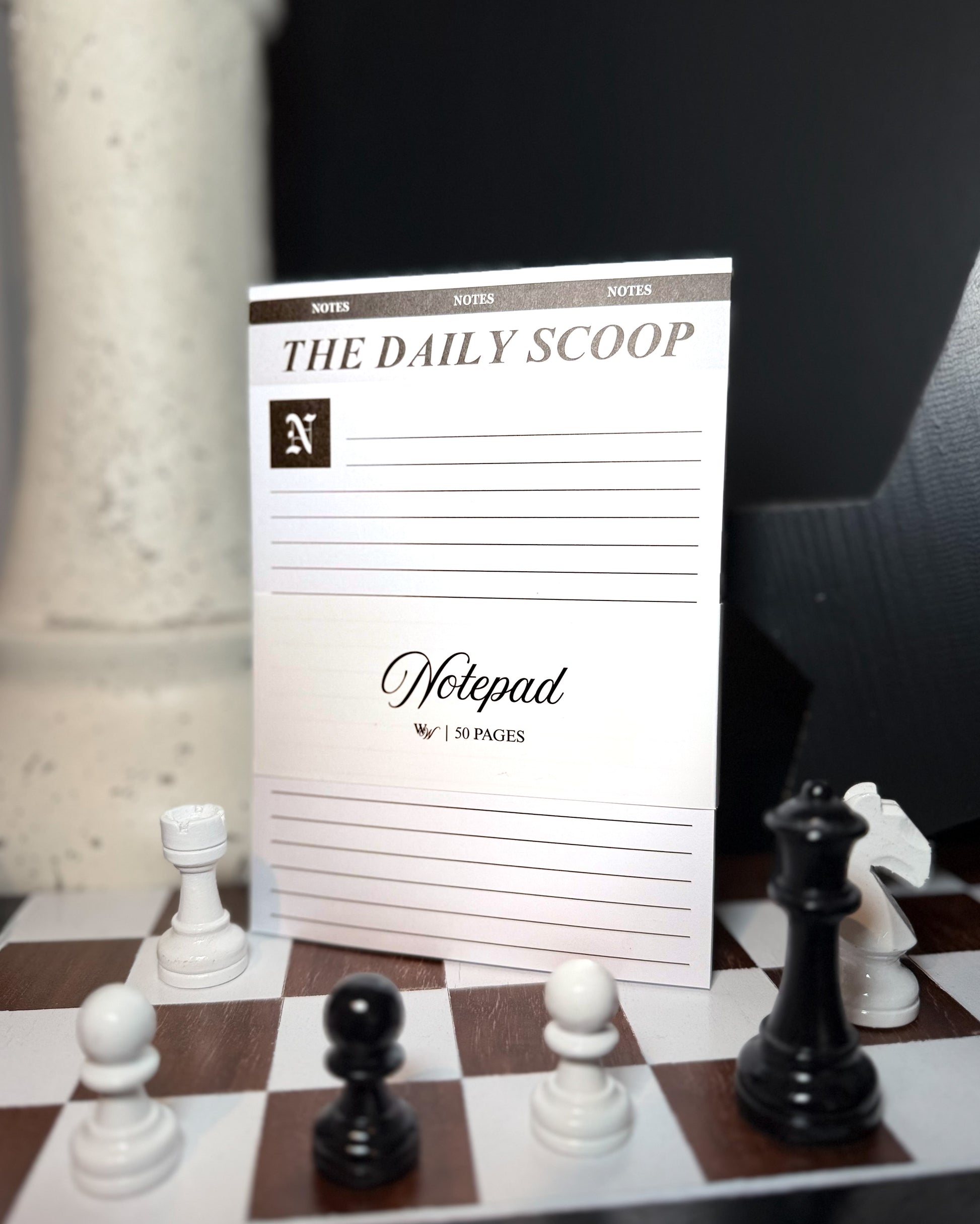 Notepad titled 'The Daily Scoop' on a chessboard with chess pieces.