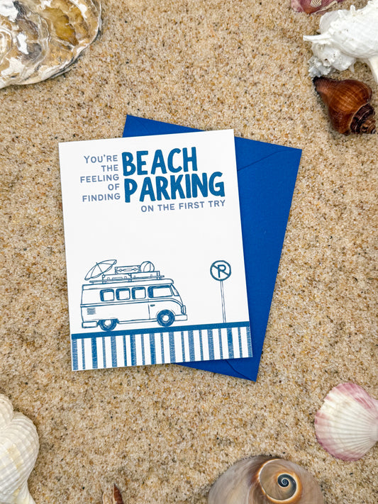 Card with a van illustration and text on sand with shells