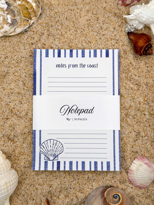 Notepad with blue stripes and shell design on a sandy background