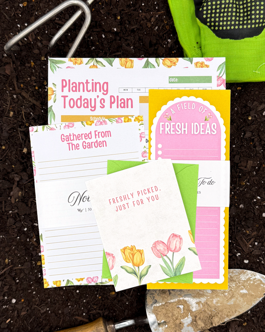 Gardening-themed stationery items including a planner, to-do list, and cards on a soil background.